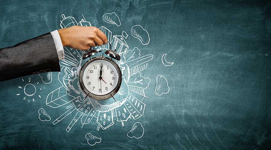 A hand holding a clock Description automatically generated