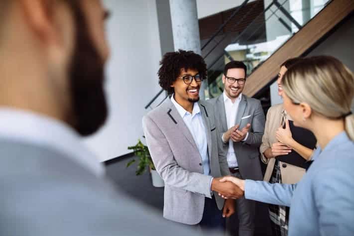 A person shaking hands with a person Description automatically generated